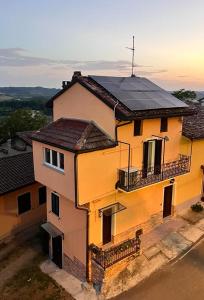 uma grande casa amarela com um telhado preto em La Casetta di Treville em Ozzano Monferrato