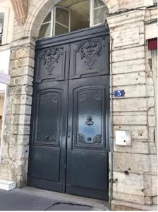 a large black door on the side of a building at Studio lyonnais calme 4pers Jacobins-Bellecour in Lyon