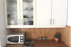 a kitchen with white cabinets and a microwave at Studio lyonnais calme 4pers Jacobins-Bellecour in Lyon