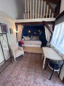 a small living room with a couch and a staircase at Gîte cosy entre Tours et Amboise in Vernou-sur-Brenne