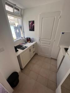 a kitchen with a white door and a tile floor at Gîte cosy entre Tours et Amboise in Vernou-sur-Brenne