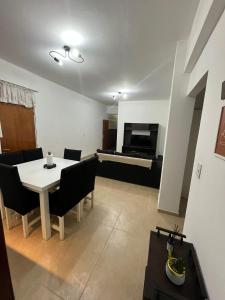 sala de estar con mesa blanca y sillas negras en DEPARTAMENTO 412 en Mendoza