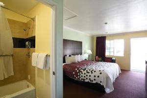 um quarto de hotel com uma cama e uma banheira em Morro Bay Beach Inn em Morro Bay