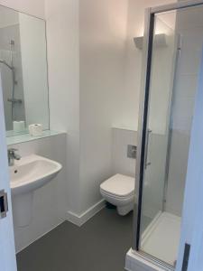 a white bathroom with a toilet and a sink at The Signature Suite in Bradford