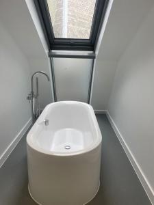 a white bath tub in a room with a window at The Signature Suite in Bradford
