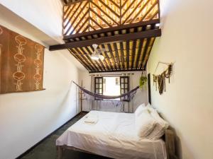 a bedroom with a bed and a wooden ceiling at Localização Incrível - Praia e Vila in Praia do Forte