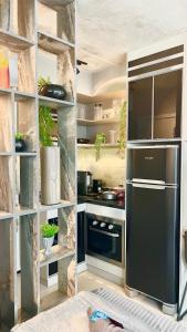 a kitchen with a black refrigerator and some shelves at 1318 - Rentaqui Studio Frei Caneca Premium in Sao Paulo