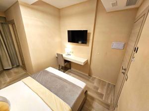 Habitación con cama, escritorio y TV. en Astoria Supreme - Modern Boutique Suites en Lecce
