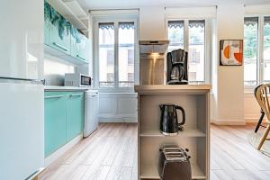 eine Küche mit blauen Schränken und einer Kaffeemaschine auf einem Regal in der Unterkunft Le Saint Clair charmant 3 pers - Caluire et Cuire in Caluire-et-Cuire + 28 Fotos