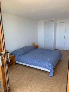 Schlafzimmer mit einem blauen Bett und weißen Schränken in der Unterkunft Maison Gaou Benat, magnifique vue mer in Bormes-les-Mimosas