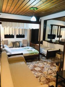 a bedroom with two beds and a large mirror at Archontiko Ouranias in Makrinitsa