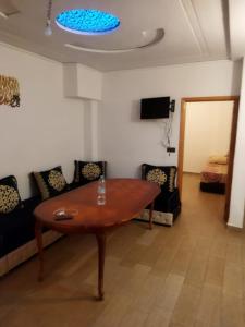 ein Wohnzimmer mit einem Tisch und einem Sofa in der Unterkunft Apartamento in Saidia 