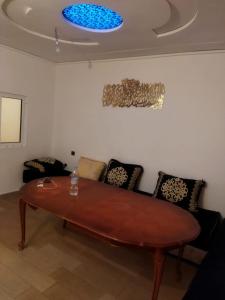 ein Wohnzimmer mit einem Holztisch und Stühlen in der Unterkunft Apartamento in Saidia 