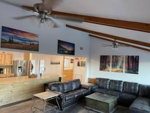 a living room with a leather couch and a kitchen at OVERLOOK LODGE in Banner Elk