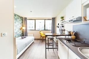 a small apartment with a bed and a kitchen at Le Guérin cosy studio 2 pers Tête d'Or in Villeurbanne