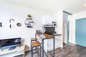 een keuken met een bureau en een tv in een kamer bij Le Guérin cosy studio 2 pers Tête d'Or in Villeurbanne