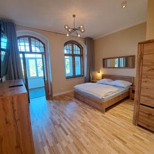 a bedroom with a bed and two windows at Apartament Piastowski in Świeradów-Zdrój