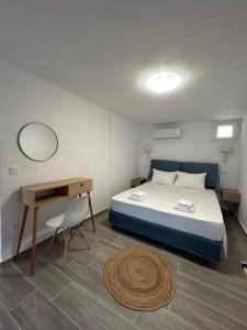 a bedroom with a bed and a table and a desk at DK Square in Andros