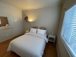 a bedroom with a bed with white sheets and a window at 1 Bedroom & Office Near Caltrain and Stanford in Palo Alto