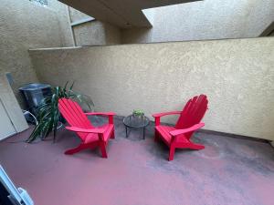 two red chairs and a table in front of a wall at 1 Bedroom & Office Near Caltrain and Stanford in Palo Alto