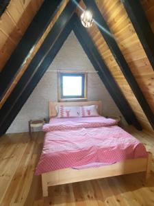 ein Schlafzimmer mit einem Bett im Dachgeschoss in der Unterkunft Runolist Chalet in Žabljak