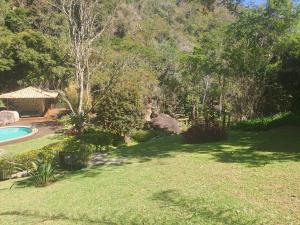 a yard with a swimming pool and a house at Casa Riacho Verde in Petrópolis
