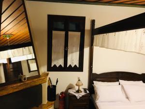 Schlafzimmer mit einem Bett und einem Wandspiegel in der Unterkunft Archontiko Ouranias in Makrinítsa