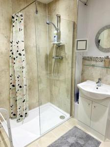 een badkamer met een douche en een wastafel bij NKN cosy maisonette close to train station, food, shopping in Kent