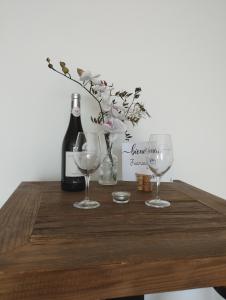 - une bouteille de vin et 2 verres à vin sur une table dans l'établissement Studio à Bellegarde, à Bellegarde