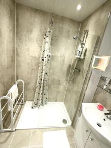 een badkamer met een douche en een wastafel bij NKN cosy maisonette close to train station, food, shopping in Kent