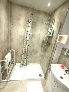 a bathroom with a shower and a sink at NKN cosy maisonette close to Dartford train station, free parking, food, shopping in Kent