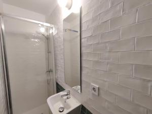 een witte badkamer met een wastafel en een spiegel bij Antic Apartament in Manresa