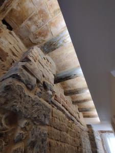 Cette chambre est dotée d'un mur en pierre et d'un plafond. dans l'établissement Antic Manresa 2, à Manresa
