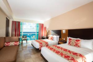 une chambre d'hôtel avec deux lits et un canapé dans l'établissement Krystal Cancun, à Cancún