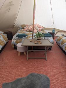 a room with two beds and a table in a tent at Stay Wild Retreats 'Glamping Pods and Tents' in Wrexham