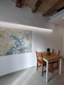 een eetkamer met een tafel en een schilderij aan de muur bij Antic Apartament in Manresa
