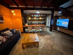 Aconchegante Casa Buzios في بوزيوس: غرفة معيشة مع أريكة وطاولة