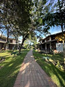 un camino en un parque con árboles y edificios en Aconchegante Casa Buzios en Búzios