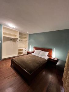 een slaapkamer met een bed en twee nachtkastjes en twee lampen bij 49 Hostel in Toronto