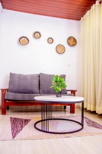 ein Wohnzimmer mit einem Sofa und einem Tisch in der Unterkunft Mwiza in Kigali