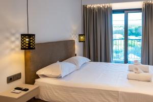 a bedroom with a large white bed with a window at PARGA 4 SEASONS VILLAS in Parga