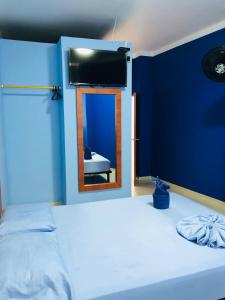 JamundíにあるHOTEL EMPERADOR PREMIUMの青いベッドルーム(ベッド1台、鏡付)