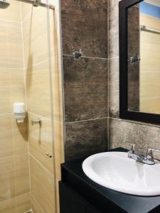 a bathroom with a sink and a mirror at HOTEL EMPERADOR PREMIUM in Jamundí