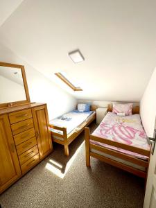 ein Schlafzimmer mit einem Bett, einer Kommode und einem Spiegel in der Unterkunft Pejzaž Zlatibora in Zlatibor