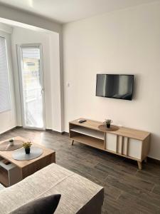a living room with a flat screen tv on the wall at Azzurro Apartman Srebrno Jezero in Veliko Gradište