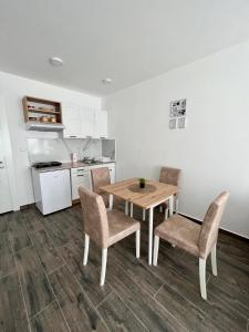 a kitchen with a table and chairs in a room at Azzurro Apartman Srebrno Jezero in Veliko Gradište
