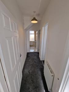 an empty hallway with a white door and a window at Luna Apartments Newcastle Gateshead 2 in Gateshead