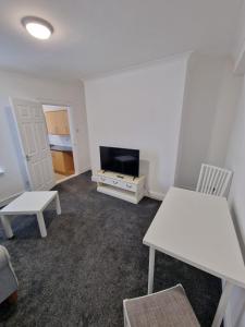 a living room with a white table and a tv at Luna Apartments Newcastle Gateshead 2 in Gateshead