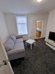 sala de estar con sofá y TV en Luna Apartments Newcastle Gateshead 2 en Gateshead