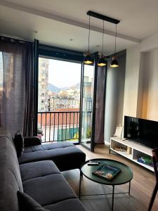 a living room with a couch and a large window at Tirana Getaway Apartments - Central in Tirana +56 photos